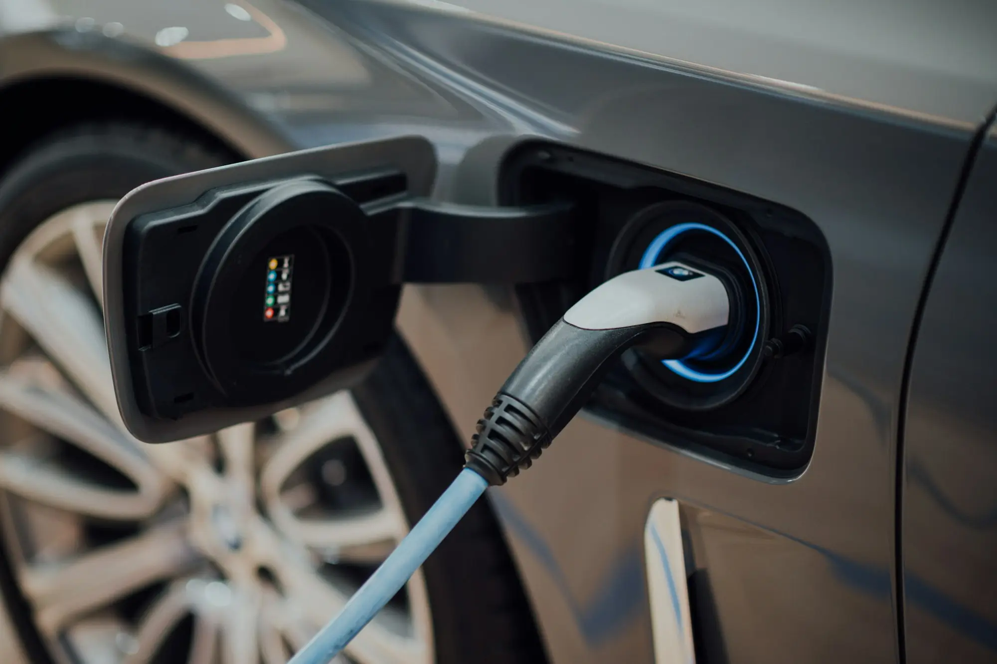 Electric or plug-in ute charging at a wall box outside a small business shed