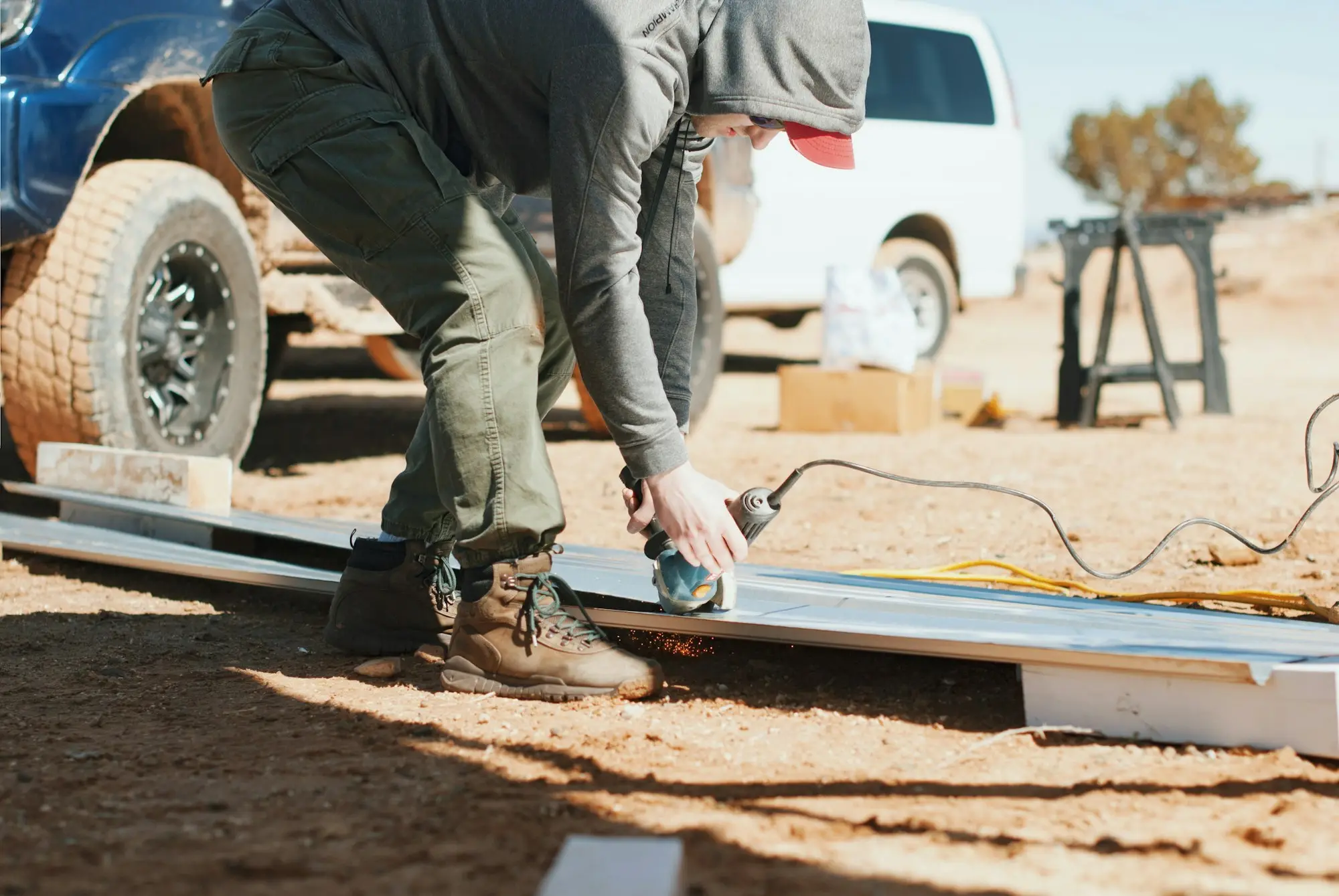 Tradie working on a job beside his ute with tools laid out on the ground